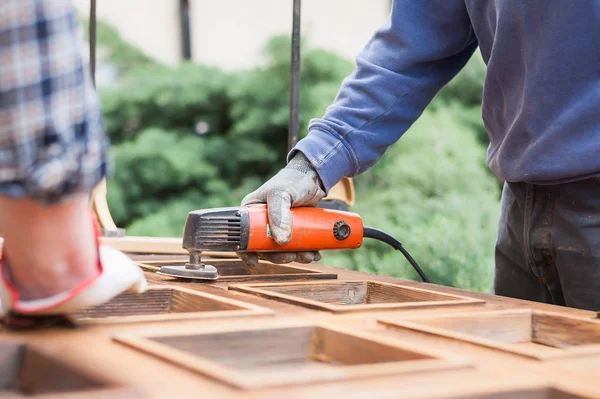 Carpenter at work with angular Sander.