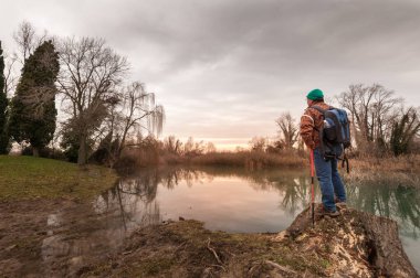 Yürüyüşçü nehir kıyısında dinleniyor. Yürüyüş ve insanlar konsept, seyahat, turizm.