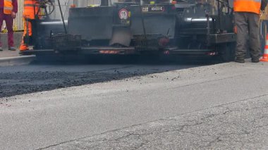 Udine, Italya-Mart 15 2017: inşaat altında kentsel yol, devam eden asfaltlama. Mavi ve turuncu üniformalı bir kürek ile işçi.