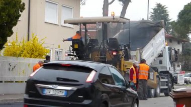 Udine, Italya-Mart 15 2017: inşaat altında kentsel yol, devam eden ashalleme. Mavi ve turuncu üniformalı bir kürek ile işçi.