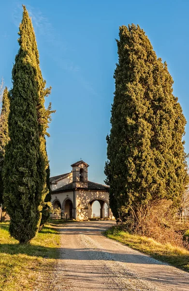 Piccola chiesa rurale del XIII secolo con cipressi . — Foto Stock