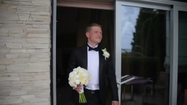幸せな新郎は彼の花嫁を待っています。若い男の日当たりの良い夏の日に屋外の結婚式で彼の花嫁を待っています。. — ストック動画