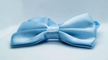 Beyaz arka planda mavi saten papyon. Şık bir tatil aksesuarı. Moda ve tatil kavramı.