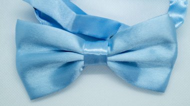 Beyaz arka planda mavi saten papyon. Şık bir tatil aksesuarı. Moda ve tatil kavramı.