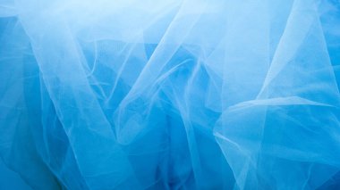 Mavi tül kumaş, kopya alanı olan bir arkaplan olarak kullanılır. Dikiş konsepti.