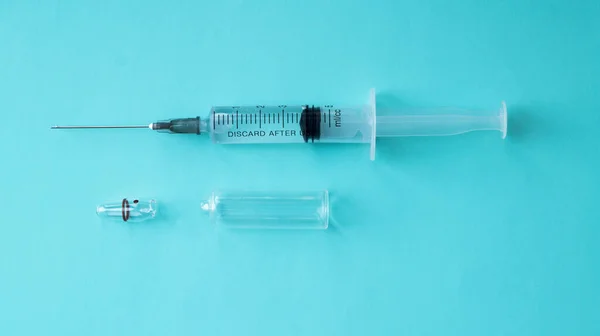 青い背景に開いたアンプルで薬で満たされた注射器 医療と医療の概念 筋肉内注射 アンプル内のワクチン — ストック写真