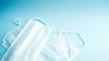 Mavi arka planda tıbbi maskeler. Virüslere karşı önlem ve koruma. Sağlık ve ilaç servisi. Coronavirus. Covid - 19.