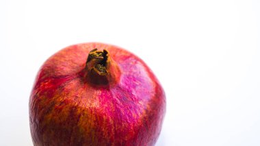 Hafif arka planda sulu, taze, olgun bir meyve. Nar parlak kırmızı. Düzgün beslenme, taze sıkılmış meyve suyu..