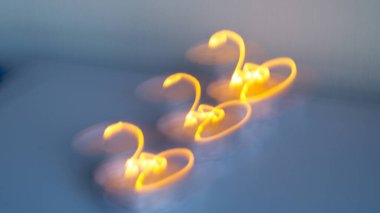 Bulanık soyut görüntü. Mumların parıltısından parla. Işıkla çiziyor. Rastgele sarı ışık çizgileri. Arkaplan, doku.