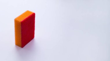 Mevsimlik temizlik. Mutfakta ve banyoda çeşitli yüzeyleri temizlemek için bir araç. Dezenfekte. Bulaşık yıkamak için turuncu sünger arka planda durur. Metin için yer.