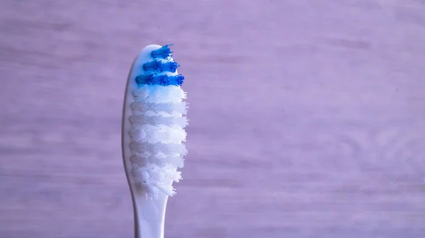 Głowa jednej szczoteczki do zębów z białym i niebieskim syntetycznym włosia na jasnym tle. Koncepcja zdrowia zębów, czystość jamy ustnej. Walka z próchnicą zębów. — Zdjęcie stockowe
