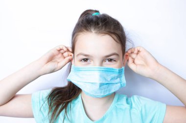 Beyaz arka planda tıbbi tek kullanımlık maske takan kız çocuğu