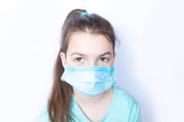 Beyaz arka planda tıbbi tek kullanımlık maske takan kız çocuğu