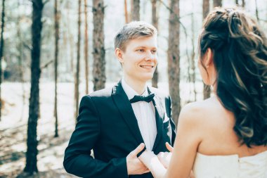 Düğün çifti, beyaz gelinlik içinde gelin ve damat ormanda yemin ediyorlar.