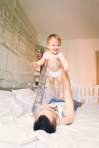 Fiatal Elegáns Modern Tetovált Apa Egy Kis Baba Fekszik Ágyban — Stock Fotó