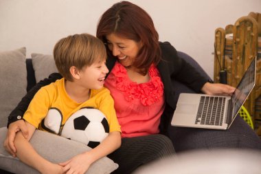 Anne covid-19 karantinasında çocuklara öğretiyor, anne çocuğa öğretiyor ve gülümsüyor.