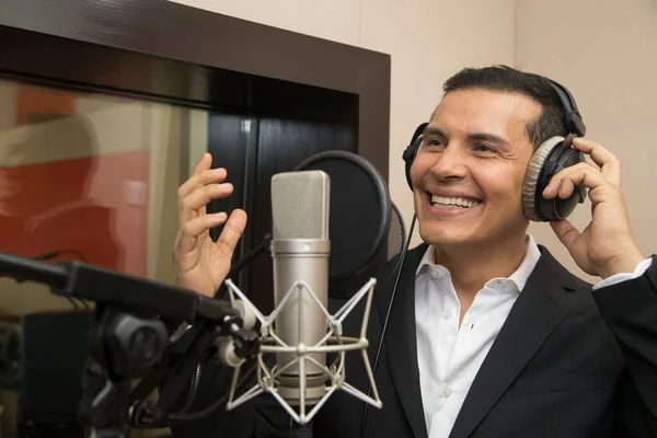 Aktör ve radyo spikeri kulaklıkları ve mikrofonuyla film kaydediyor, radyo sahnesi çekiyor ve şarkı söylüyor.