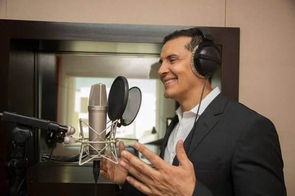 Aktör ve radyo spikeri kulaklıkları ve mikrofonuyla film kaydediyor, radyo sahnesi çekiyor ve şarkı söylüyor.