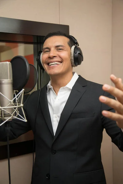 Aktör ve radyo spikeri kulaklıkları ve mikrofonuyla film kaydediyor, radyo sahnesi çekiyor ve şarkı söylüyor.