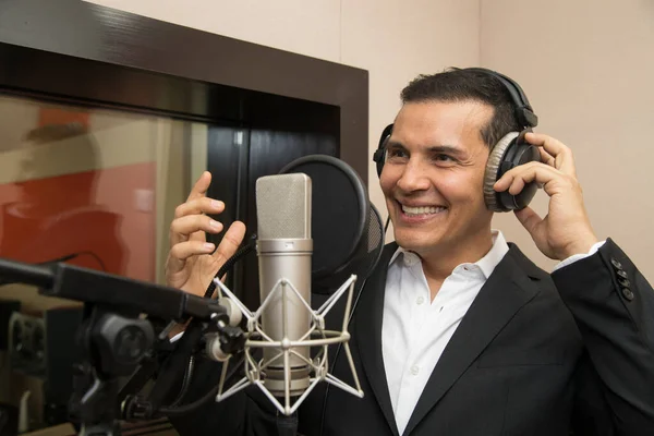 Aktör ve radyo spikeri kulaklıkları ve mikrofonuyla film kaydediyor, radyo sahnesi çekiyor ve şarkı söylüyor.