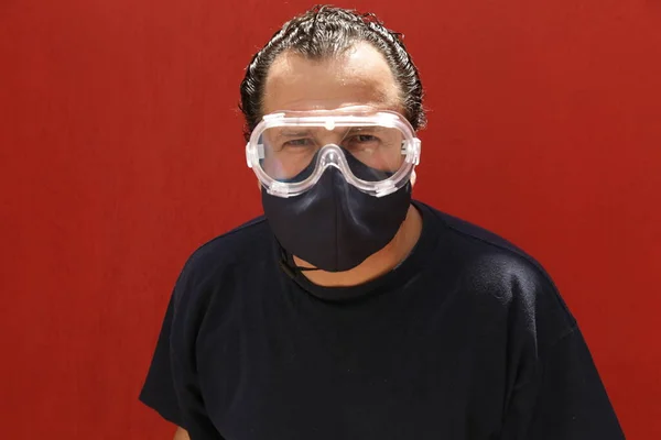 Kırmızı Arka Planda Beyaz Bir Adam Gözlüklü Koruyucu Maskeli Ciddi — Stok fotoğraf