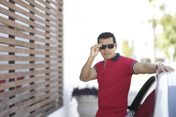 Yakışıklı yönetici dışarıda teknoloji ve lüks bir araba kullanıyor.