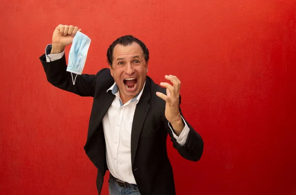 Kolları havada bir iş adamı koruyucu maskesini çıkarıp gülümsüyor. İnsan Coronavirus 'a karşı savaşı kazanır.