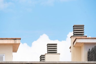 Büyük beyaz bulutlu ve arkasında mavi gökyüzü olan bir ev..