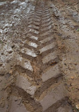 Traktör ayak iziyle desenli çamurlu yol..