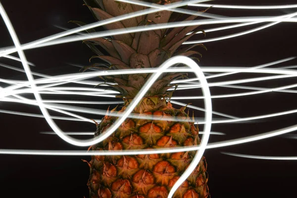 Ana nesne olarak bir ananas ve bir el feneri ile uzun pozlama.