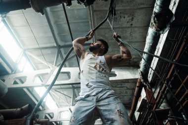 Fabrikada çalışan işçi, elektrik döşeyen, yırtık iş şekli, spor figürü.
