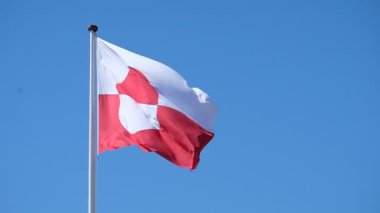 Grönland bayrağı, 1080p120 fp 'lik derin mavi gökyüzüne karşı rüzgarda dalgalanıyor.
