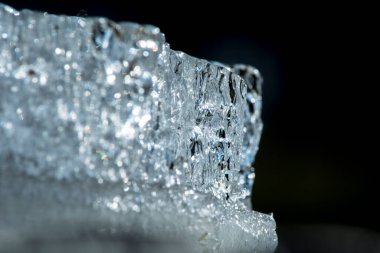 Siyah arkaplanda bir buz parçasının yakın plan görüntüsü.