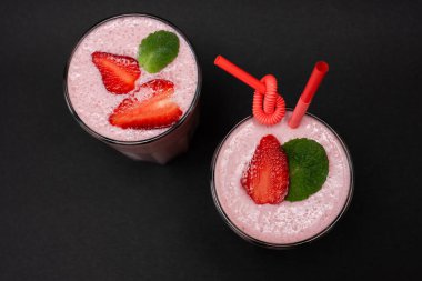 Çilekli milkshake. Meyve püresi. bir siyah arkaplan üzerinde (yukarıdan görünüm)