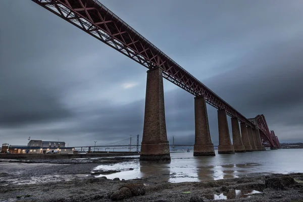 The new Queensferry Crossing bridge (on the right) over the Firth of Forth with the older Forth Road bridge (on the left) and with the iconic Forth Rail Bridge in the far left.