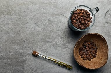 Hindistan cevizi kabuklu kavrulmuş kahve çekirdekleri, ahşap arka planda.