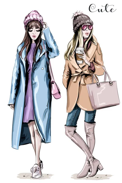 İki moda kadın. El şık güzel kadınların kış giysileriyle çekilmiş. Moda kış giysileri. Kroki.