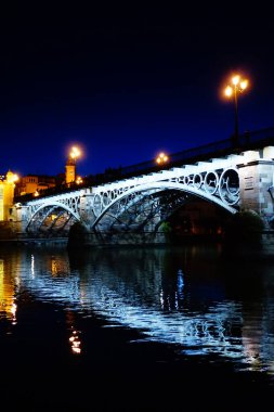 Seville 'deki Triana Köprüsü, Guadalquivir nehri ile, gün batımında.