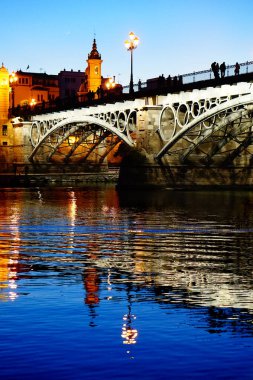 Seville 'deki Triana Köprüsü, Guadalquivir nehri ile, gün batımında.