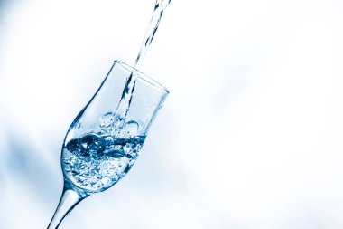 Bir su akıntısı bardağa doluyor. Su sıçrıyor