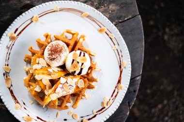 waffle topped with vanilla ice cream and banana slices