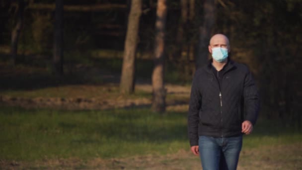 Gelukkig positief genezen pandemische man doet zijn medische masker van coronavirus bescherming buiten en glimlachen — Stockvideo