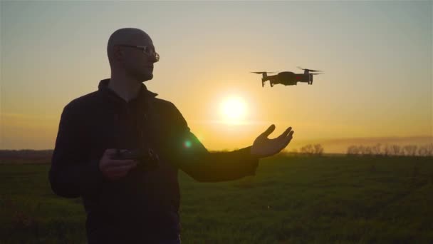 Close up man stak zijn hand uit voor kleine slimme quadcopter zal landen op palm in stralen van de avondzon — Stockvideo