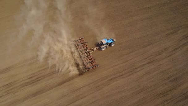 ディスクプローと作物を播種するためのフィールドを準備する矢印を持つ空中ビューファームトラクター — ストック動画