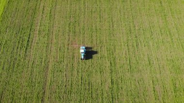 Gübre püskürtücü ile hava görüşü traktörü yeşil buğday veya arpa ile tarlada hareket eder