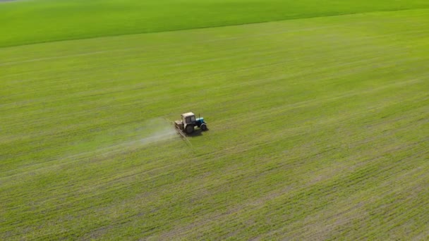 Vista aérea de la pulverización de tractores agrícolas con productos químicos en el campo — Vídeos de Stock