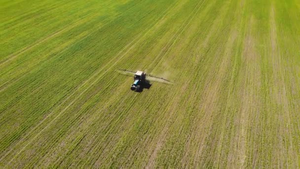 Vista aérea del agricultor en productos químicos de pulverización de tractores en el campo — Vídeo de stock