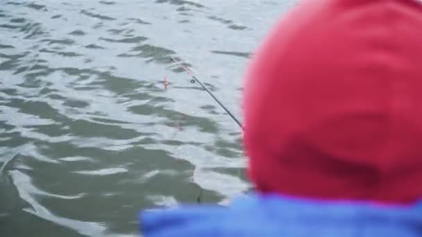 寒い曇りの日にフロートロッドと川で若い男の子釣り — ストック動画