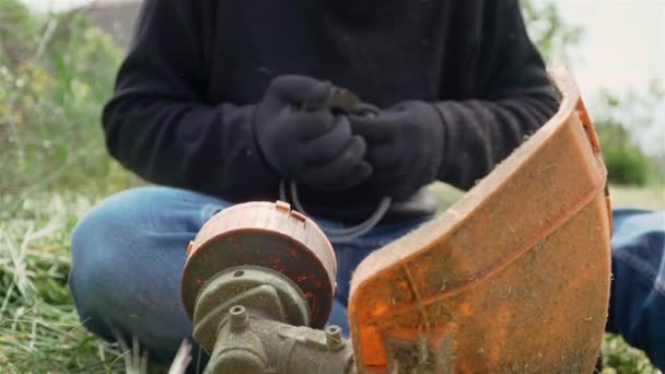 Ветровая линия садовника мужского пола на барабане электрической газонокосилки для стрижки травы — стоковое видео