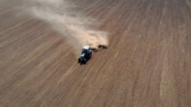 Tozlu tarlalarda, ekin ekimi için toprağı hazırlayan diski olan hava manzaralı tarım traktörü.